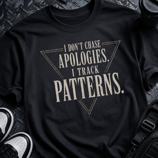 Black unisex T-shirt featuring the distressed quote I Don’t Chase Apologies. I Track Patterns.